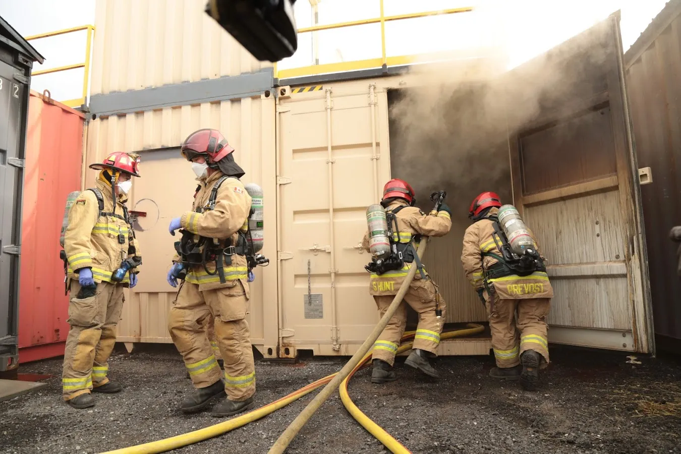 Ottawa Fire Services firefighters in full PPE during a daylight live training evolution at the OFS training facility